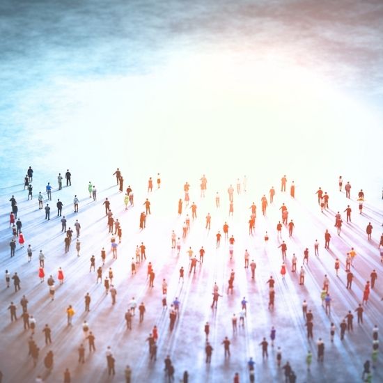 Many dozens of tiny people facing a bright light amid a sky background representing the many influences.